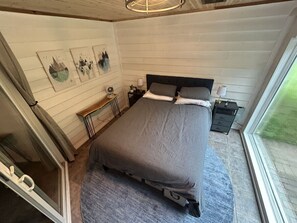 Une chambre à coucher avec un lit, des tables de chevet et des œuvres d’art accrochées au mur.