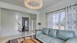 A spacious living room with a light blue sofa, a wooden coffee table, and a chandelier. - Jackson Getaway + Yard, 4 Mi to High Falls SP (Jackson)