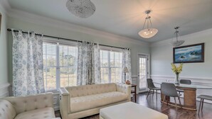 A spacious room with a large window, a sofa, a chair, a desk, and a painting on the wall. - Jackson Getaway + Yard, 4 Mi to High Falls SP (Jackson)
