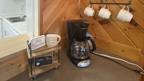 A cozy room with wooden walls, a coffee station, and a sign reading "Ski Lodge".