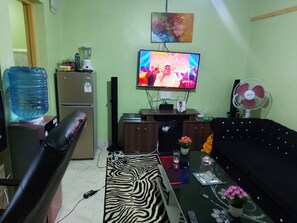 Relax in this cozy space with a TV, refrigerator, and water dispenser at your fingertips.