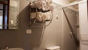 Ein Badezimmer mit Waschbecken, Toilette und einem Handtuchhalter mit mehreren Handtüchern.