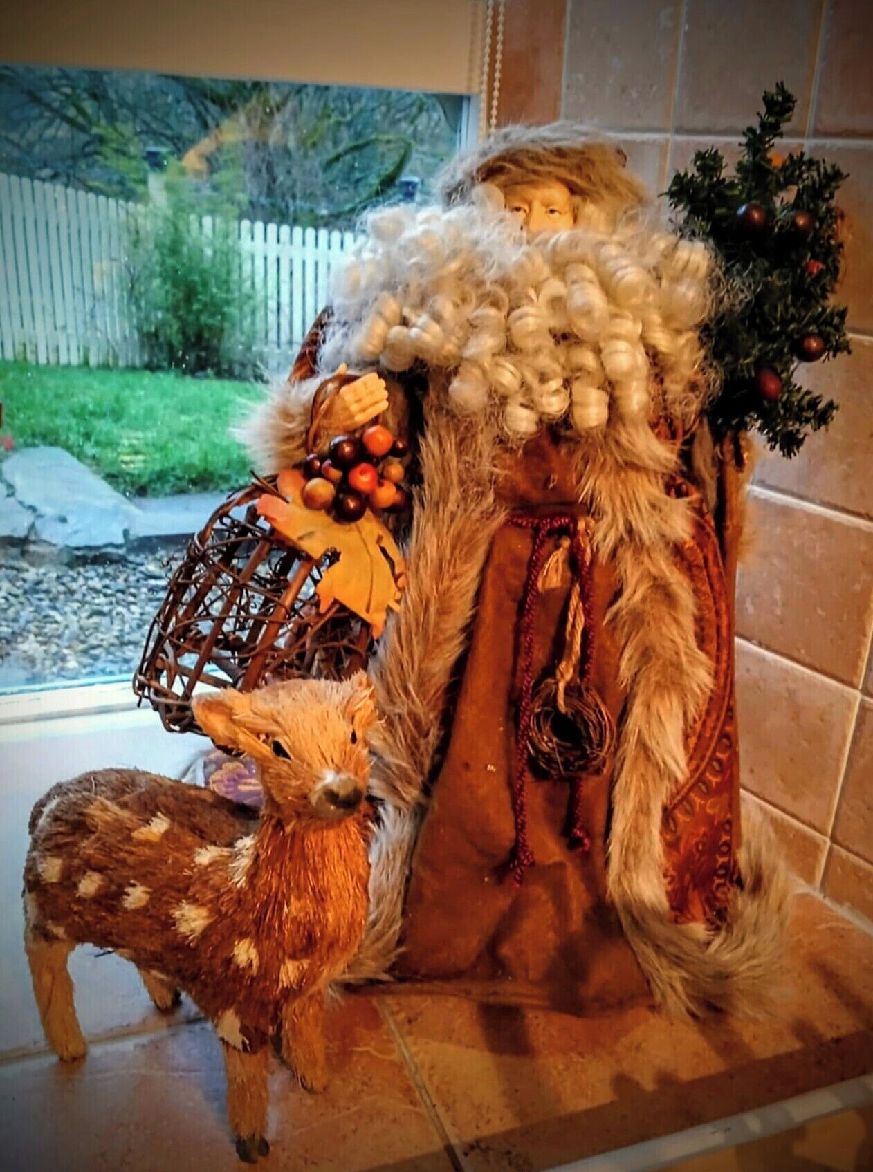 Et værelse med et stort vindue, en trædør og et lille juletræ.