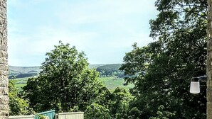 A garden with a gravel path, wooden fence, and a view of the countryside. - Butterfly Lodge, historic converted cart house with rural country views (Wearhead)
