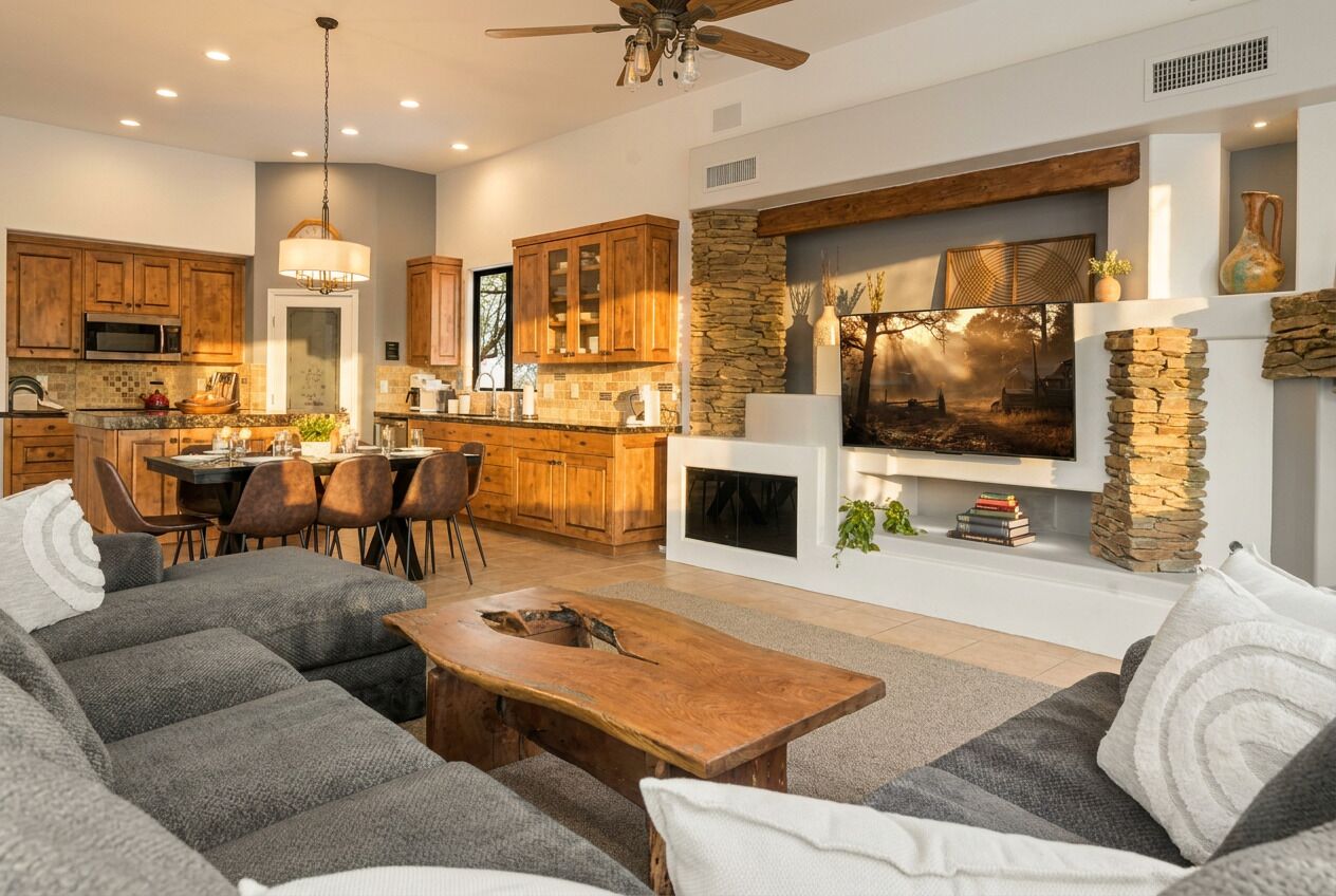 A modern living room with a fireplace, a dining area, and a kitchen with wooden cabinets.
