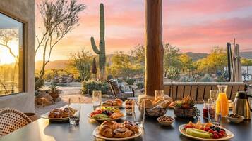A dining table set with breakfast items, a cactus, and a scenic view.