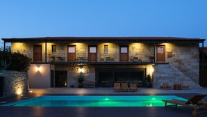 A two-story stone house with a swimming pool, outdoor seating, and a staircase leading to the upper floor. - Casa Vieira Lobo (Arouca)