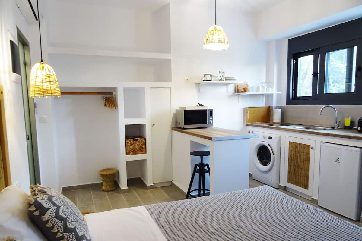 Une cuisine compacte équipée d’un lave-linge, d’un four à micro-ondes et d’un évier.