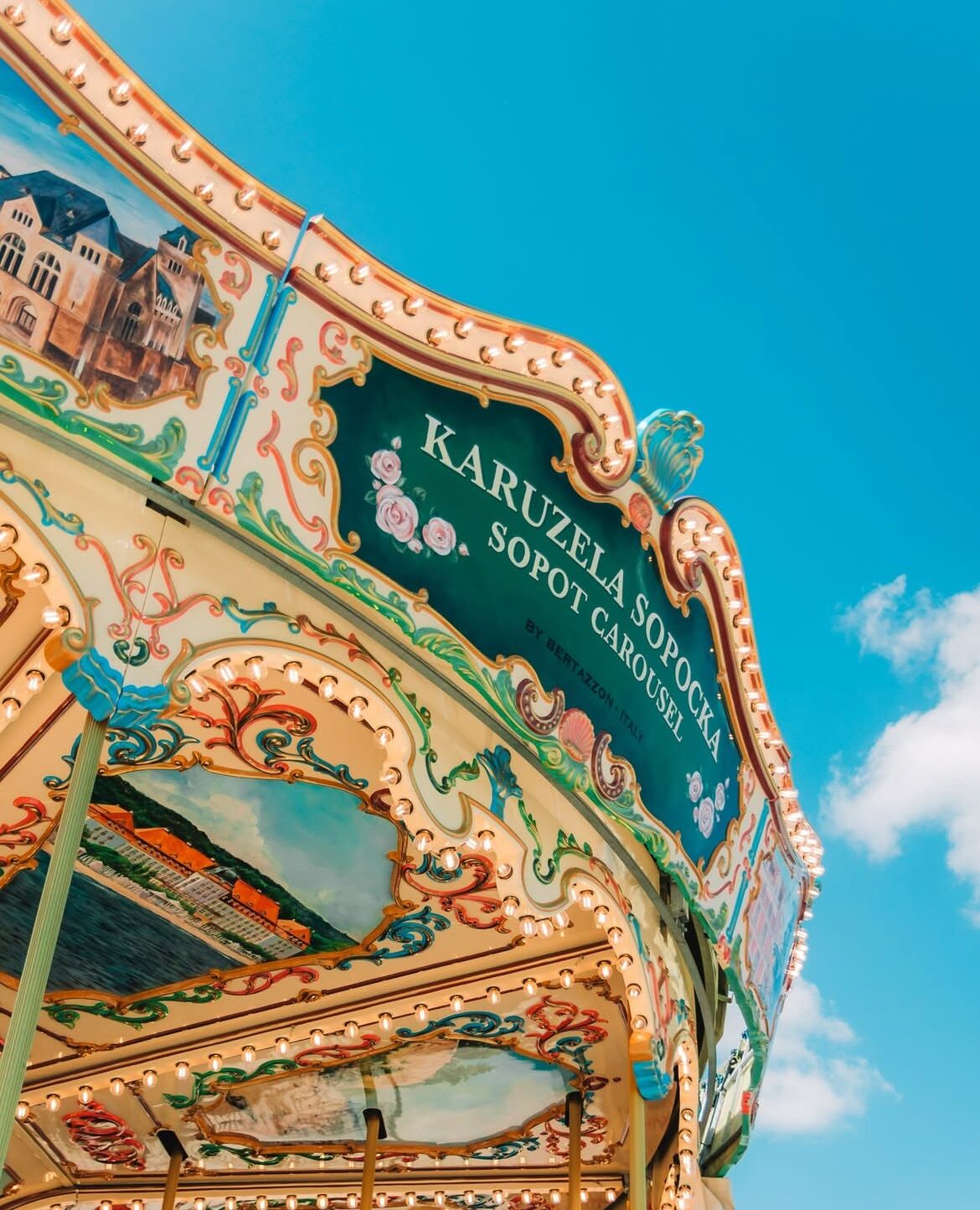 Ein Karussell mit aufwendiger Dekoration und einem Schild mit der Aufschrift 'Karuzela Sopot Karou'.