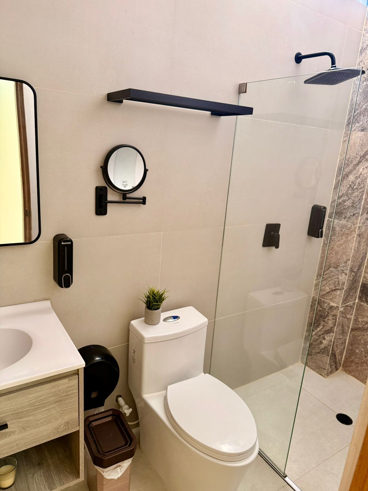Een moderne badkamer met toilet, bidet en douche.