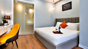 A hotel room with a bed, a desk, a chair, and a glass door. - HANZ Hotel Memory Hanoi (Hanoi)