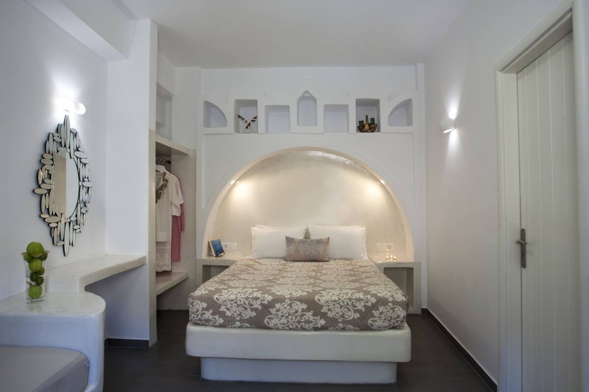 Ein Schlafzimmer mit einem großen Bett, einem Schminktisch mit Spiegel und einem Kleiderschrank.