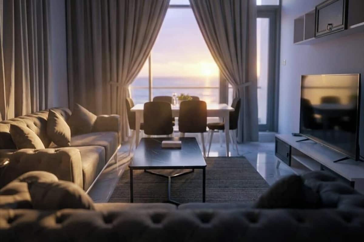 A modern living room with a sofa, coffee table, TV, and a dining area with chairs.