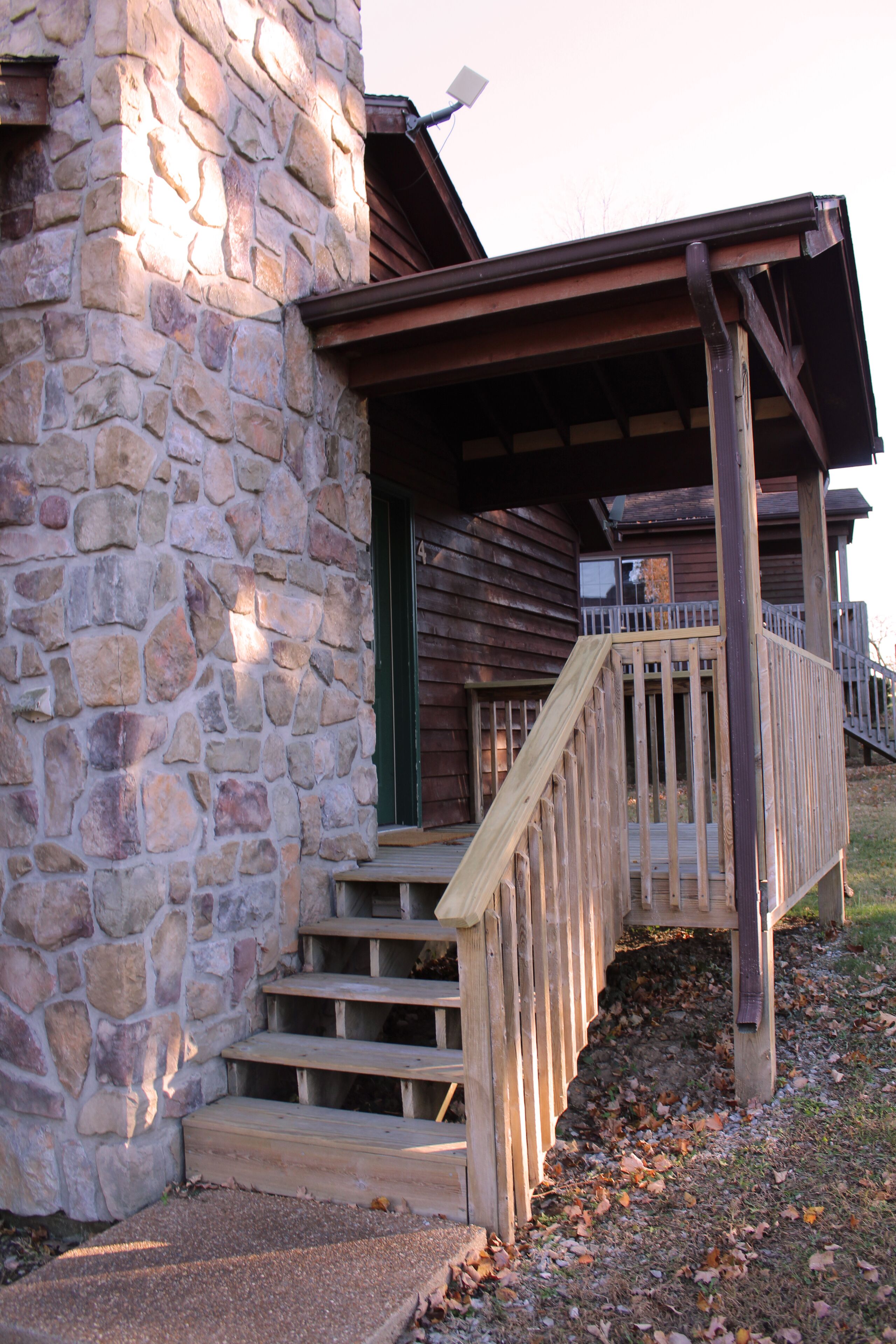 A stone building with wooden steps and a wooden porch.