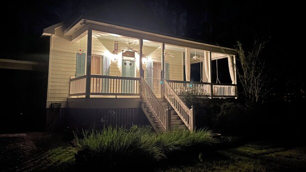 A house with a covered porch, a staircase, and a front door. - Creole-style Cottage near Fish River (Summerdale)