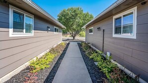 A pathway between two buildings with a tree in the center. - The Industrial - Pet Friendly Home with Garage by Boise Fairgrounds (Boise)