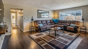 A living room with a sectional sofa, a coffee table, and a rug. - The Industrial - Pet Friendly Home with Garage by Boise Fairgrounds (Boise)