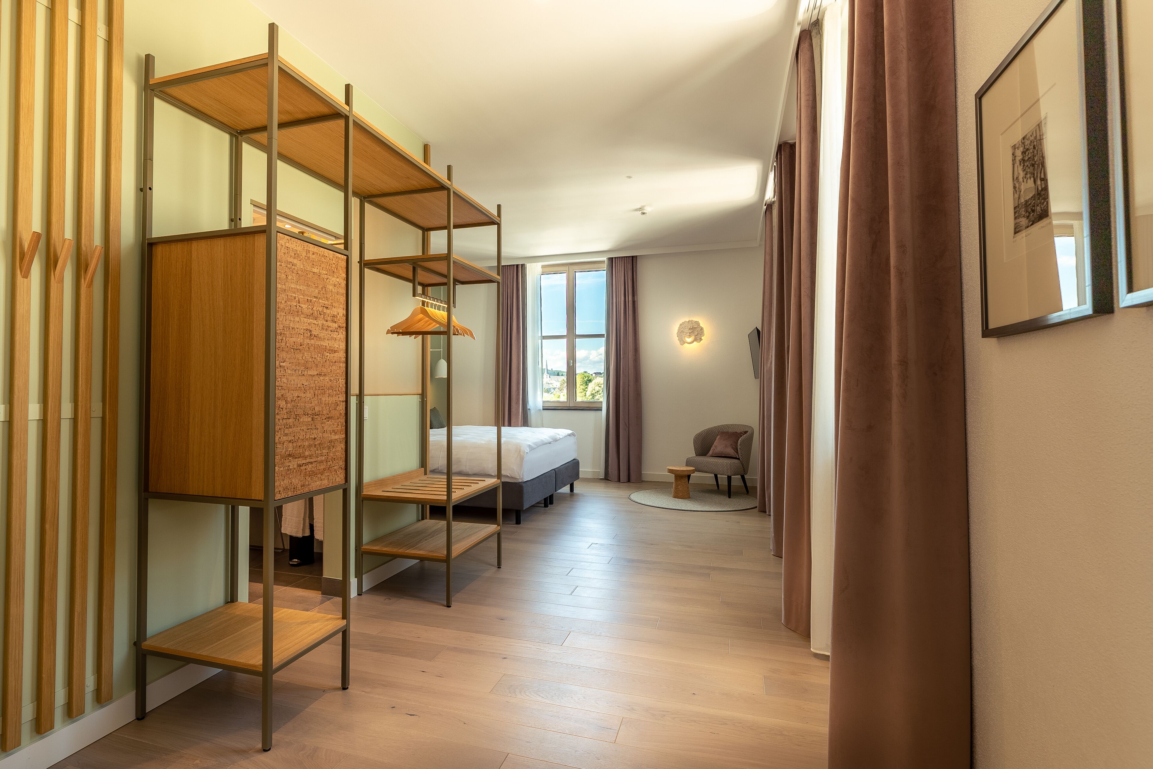Habitació d'hotel moderna amb un llit superposat, un escriptori, una cadira i una taula petita.