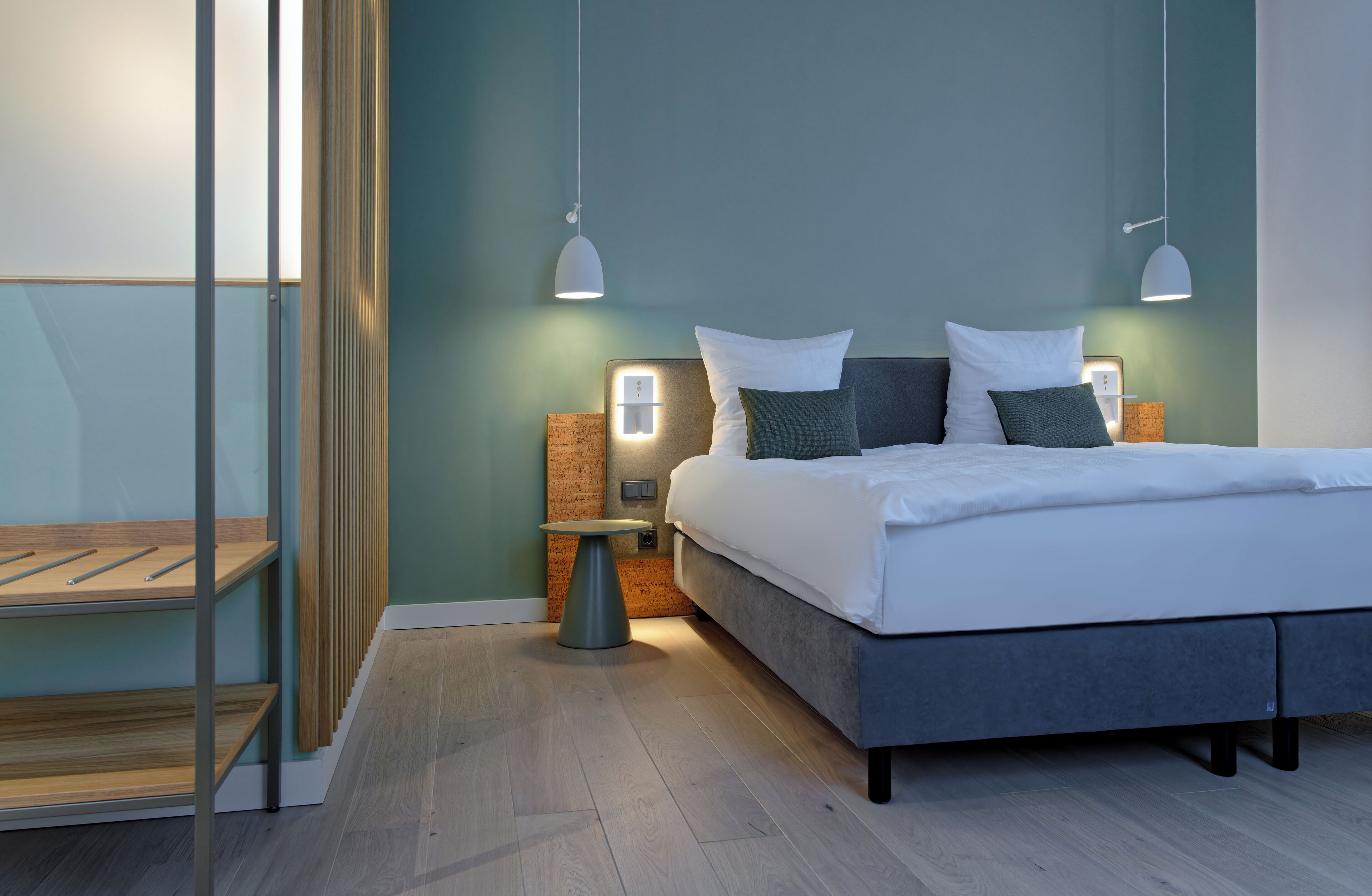 Ein modernes Schlafzimmer mit einem großen Bett, zwei Nachttischen und einer Glastrennwand.