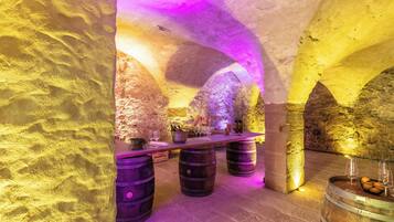 Experience the rustic charm of this cozy space with stone walls, arched ceilings, and a long dining table.