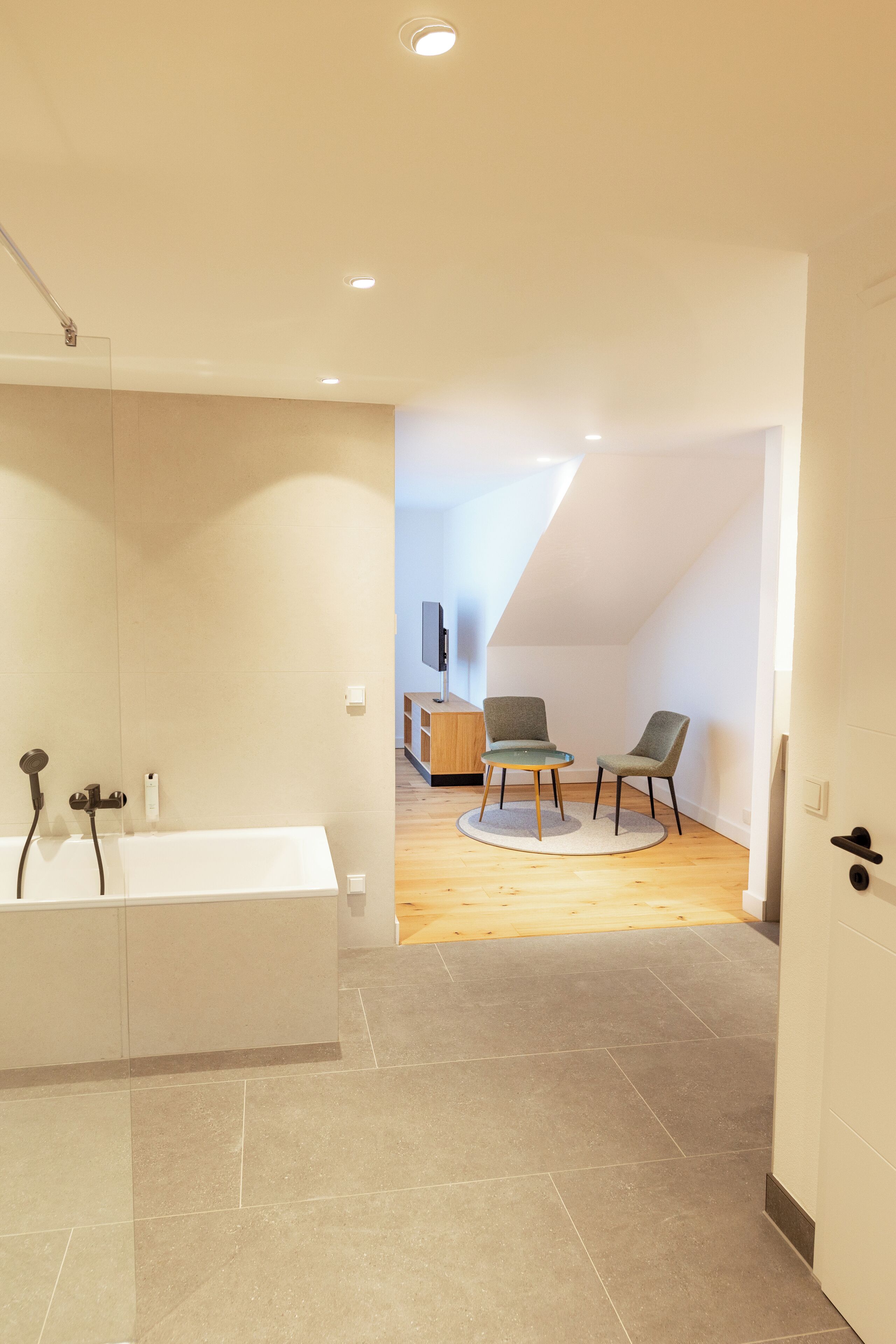 Ein modernes Badezimmer mit Badewanne, Dusche und Holzboden.