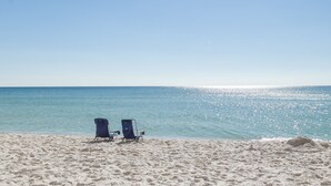 A beach with two blue beach chairs facing the ocean. - Majestic Tower 2-502 with RESERVED PARKING SPACE (Panama City Beach)