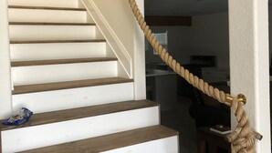 Una scala con gradini in legno e una ringhiera in corda.