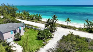 A beachfront property with a house, a sandy beach, and a clear view of the ocean. - SPECTACULAR OCEAN VIEWS 🌊Kayak, Starlink, Generator, Beach, Pickleball (Crossing Rocks)