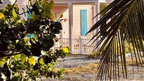 A two-story house with a covered porch and a staircase. - SPECTACULAR OCEAN VIEWS 🌊Kayak, Starlink, Generator, Beach, Pickleball (Crossing Rocks)