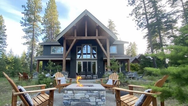 A lodge with a stone fireplace, wooden chairs, and a stone fire pit. - Luxury Suncadia Retreat- Golf Course View, Fire Pit, Pool Table, Family-Friendly (Cle Elum)