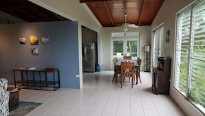 Una cocina amplia con zona de comedor, ventanas grandes y ventilador de techo.