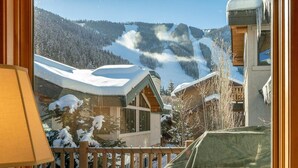 Blick auf einen Berghotelkomplex mit schneebedeckten Gebäuden und einer Skipiste.