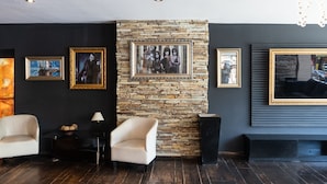 A modern living room with a stone accent wall, framed artwork, a fireplace, and a seating area. - Park Bariloche (San Carlos de Bariloche)