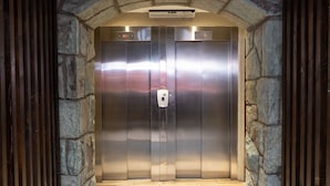 An elevator with a digital display and a hand sanitizer dispenser. - Park Bariloche (San Carlos de Bariloche)