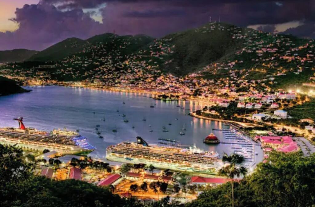 Un paysage urbain côtier avec un grand navire de croisière amarré dans un port, entouré de collines et de zones résidentielles.
