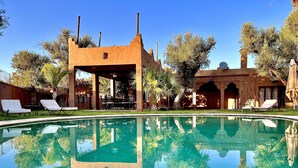A clear pool with lounge chairs and a covered seating area. - Casa Del Senator Marrakech (Aghouatim)