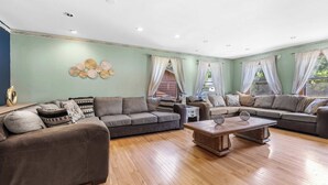 A spacious living room with a sectional sofa, a coffee table, and a decorative wall piece. - Golfer's Retreat *hot tub* *arcade* *spa* (Rockford)