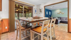 A dining area with a wooden table and chairs, a view into a living room, and a large mirror on the wall. - Golfer's Retreat *hot tub* *arcade* *spa* (Rockford)