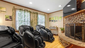 A room with massage chairs, a fireplace, and artwork on the walls. - Golfer's Retreat *hot tub* *arcade* *spa* (Rockford)