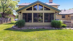 A house with a covered porch, a chimney, and a well-maintained lawn. - Golfer's Retreat *hot tub* *arcade* *spa* (Rockford)