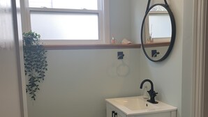 A bathroom with a toilet, sink, and window. - Cozy open concept home, walking distance to Canada Games grounds (Charlottetown)
