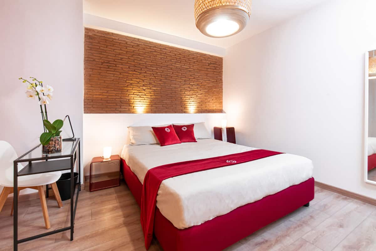 Una habitación de hotel moderna con una cama grande, un escritorio y una silla.