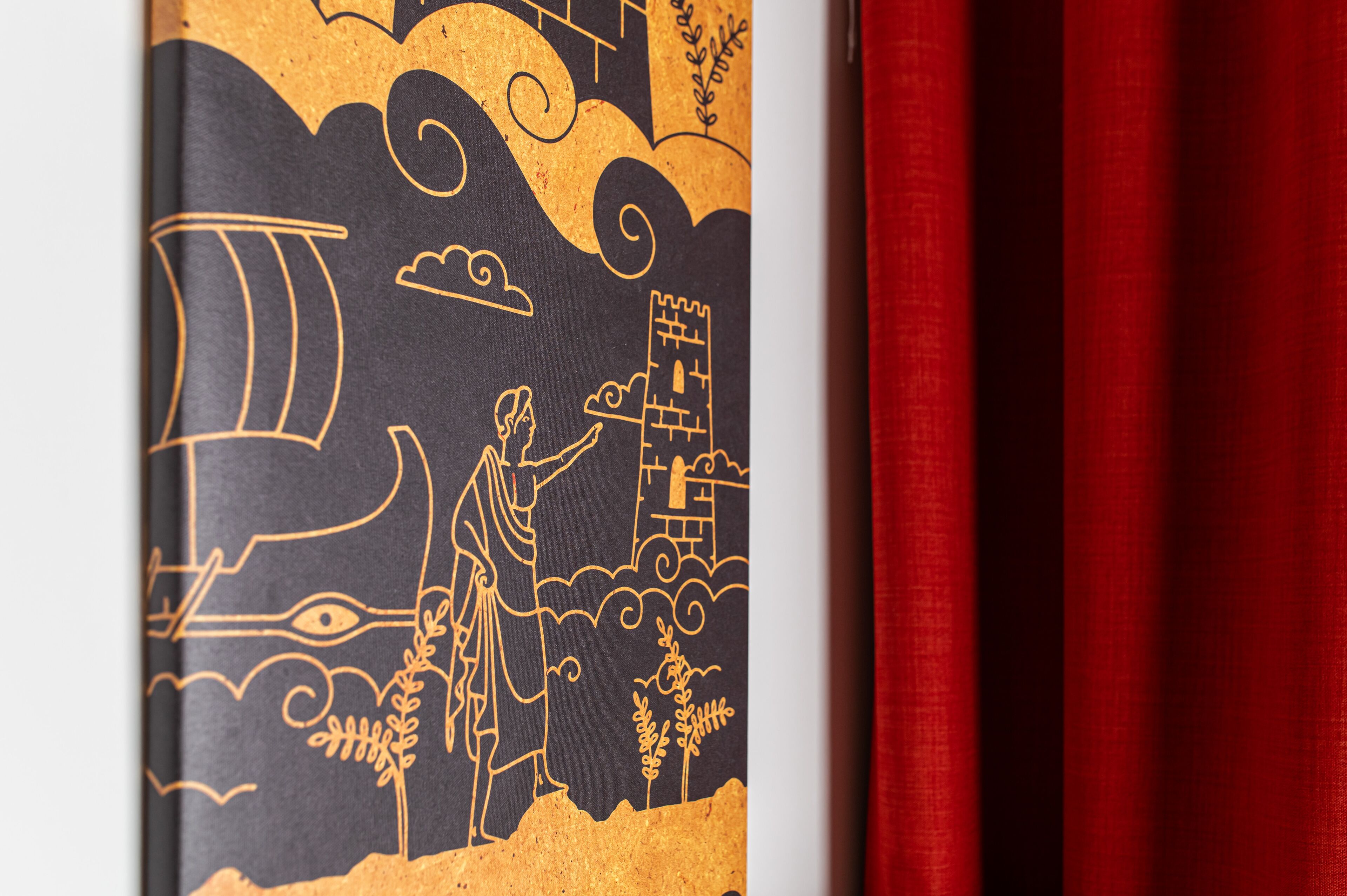 Un livre comportant une illustration dorée représentant une personne et un paysage.
