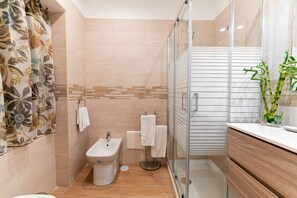 A modern bathroom with a shower, bidet, and vanity. - Neocore  (Naples)