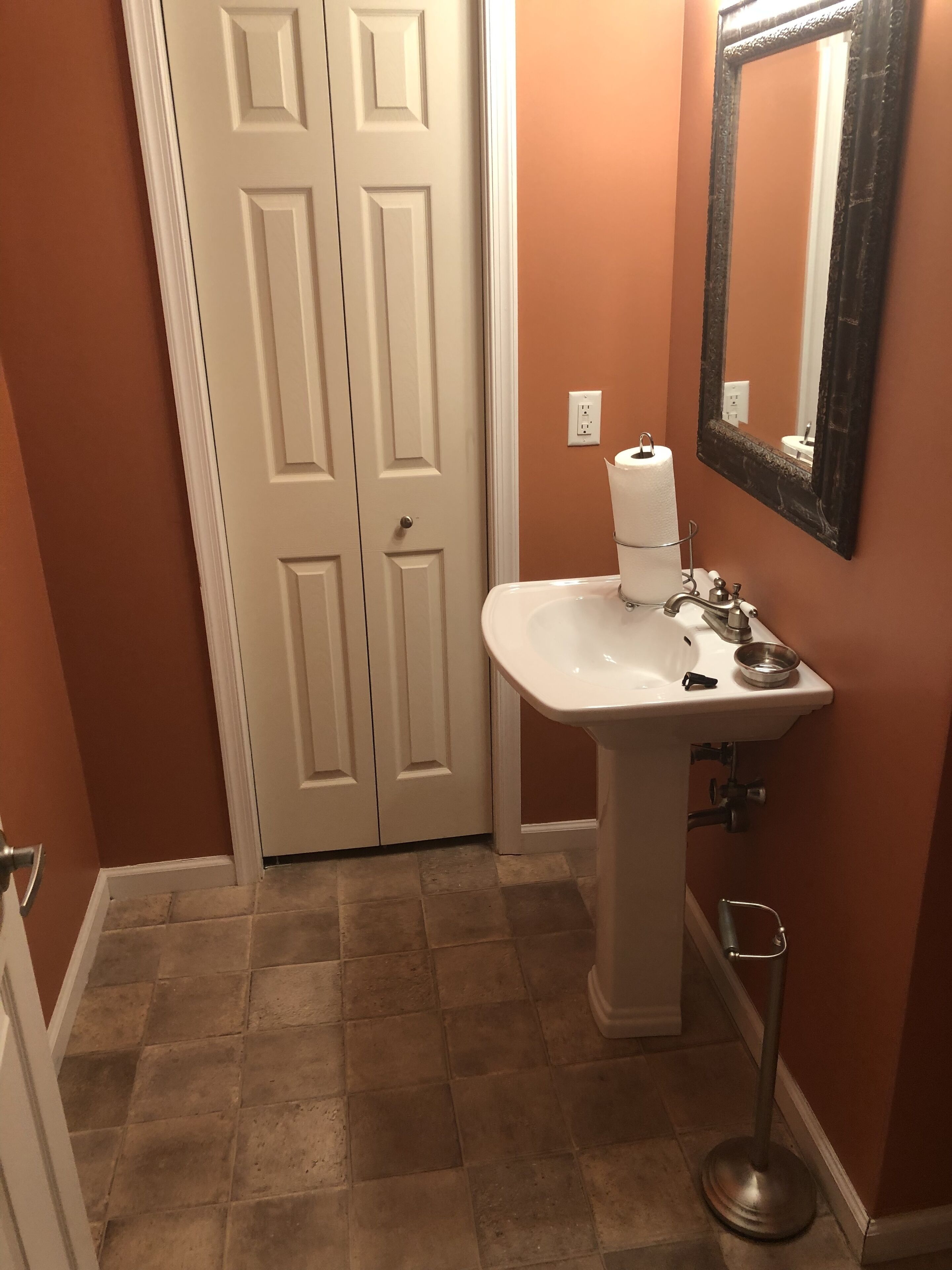 Un baño con lavamanos blanco, un espejo y un inodoro.