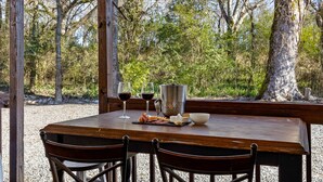 A wooden table set with a cheese platter, two glasses of red wine, a metal pitcher, and a bowl. - 1900 Farmhouse with Luxury Spa Bath, 2 Master Bedrooms, Historic Home (Whitwell)