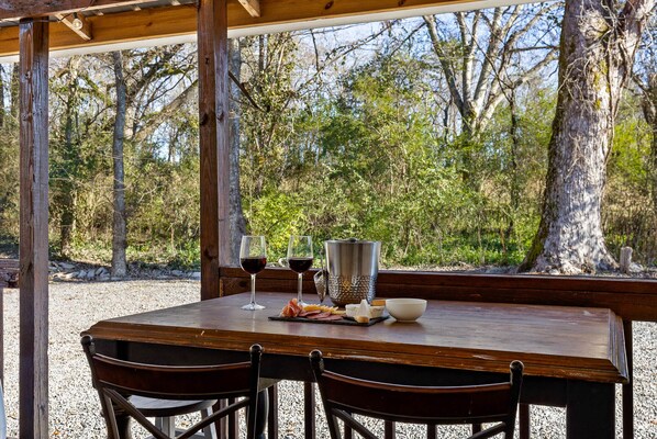 A wooden table set with a cheese platter, two glasses of red wine, a metal pitcher, and a bowl. - 1900 Farmhouse with Luxury Spa Bath, 2 Master Bedrooms, Historic Home (Whitwell)