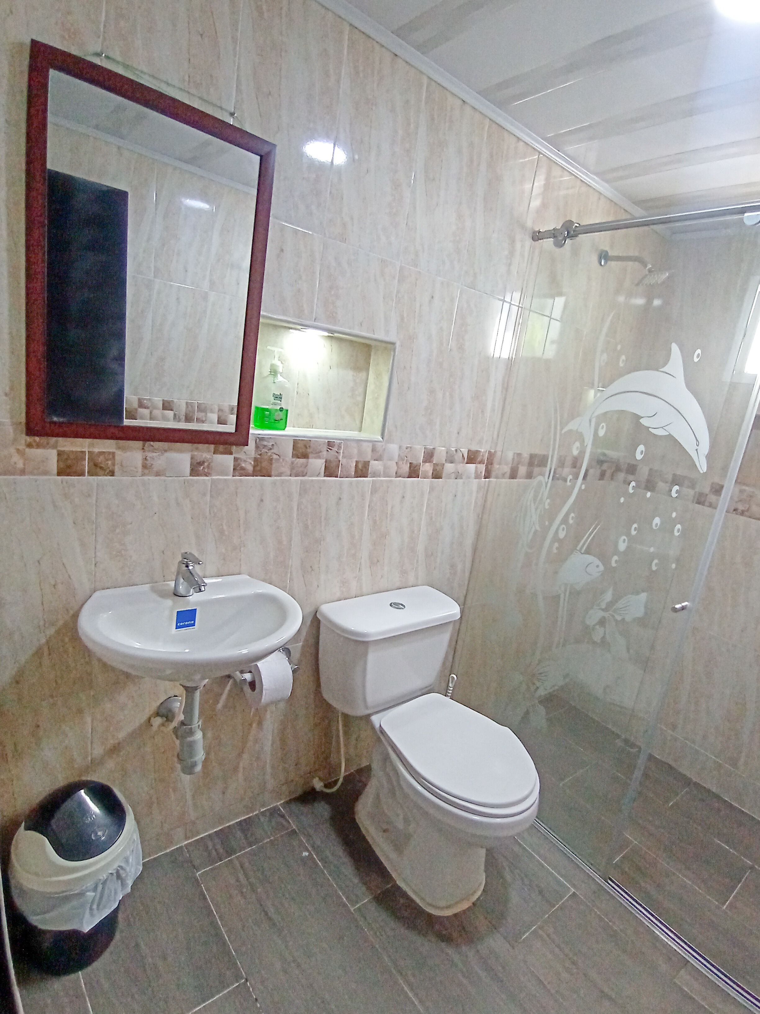 A bathroom with a sink, toilet, and a glass shower enclosure.
