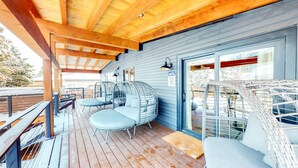 A covered deck with wooden beams, a glass door, and outdoor seating. - Summer in Park City, Dog Friendly, Game Room, Hot Tub, Grill, Playground (Park City)