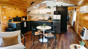 Une cuisine chaleureuse, aménagée dans le style d’un chalet, avec des murs en bois et un îlot central.